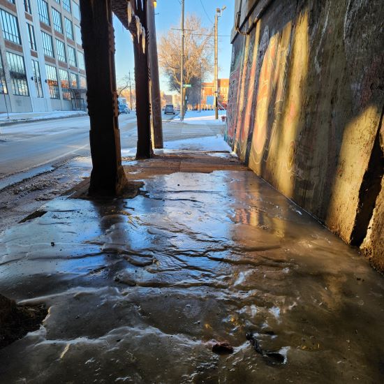 icy sidewalk under a train overpass